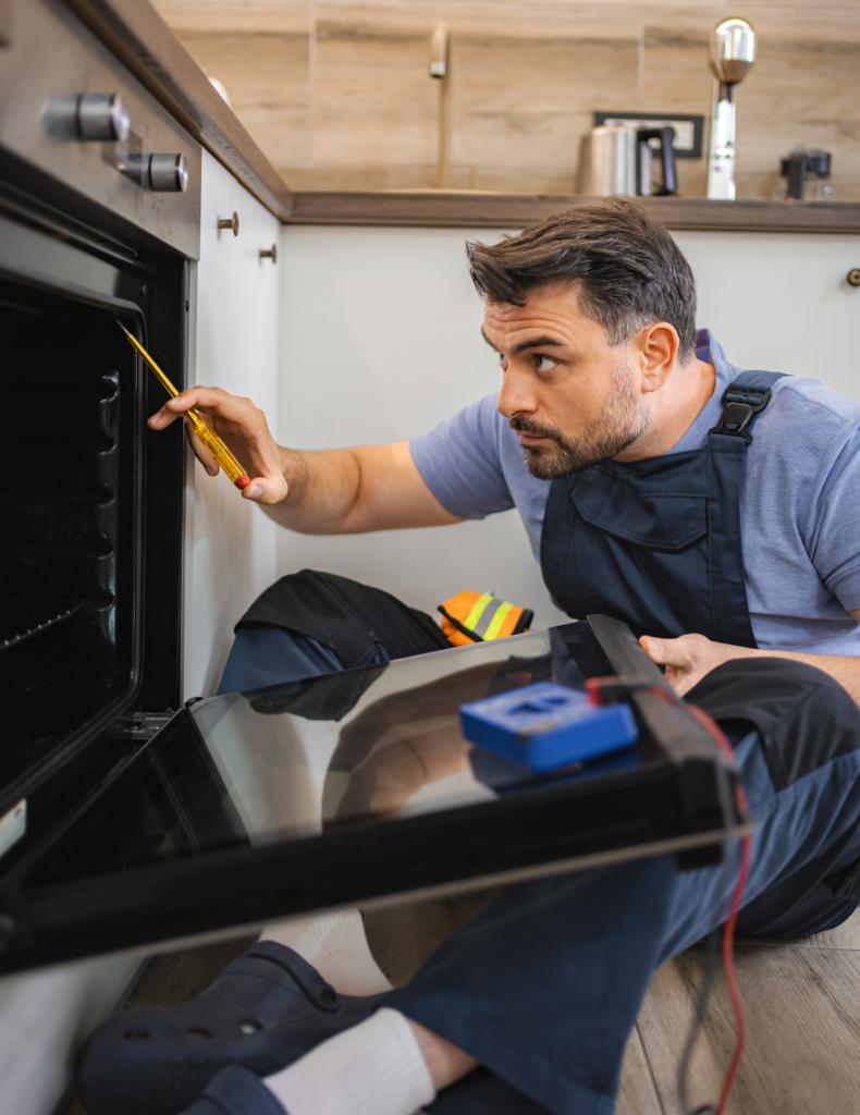 "Technician repairing a gas stove and oven in Dubai kitchen"